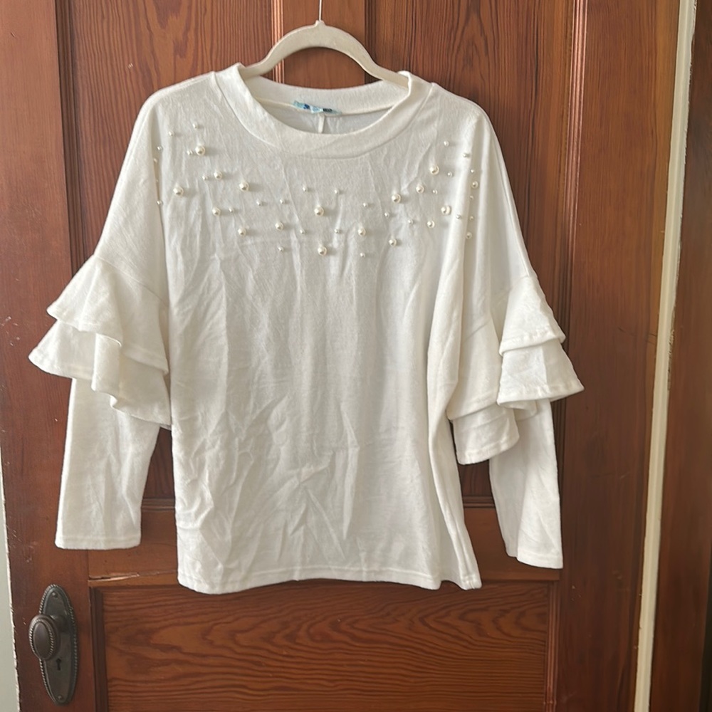 A white sweater with pearl detailing